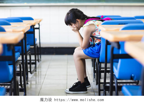 伤心的女孩坐着和思考在教室里烦躁恼火烦躁困扰